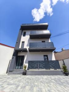 a tall white building with solar panels on it at ROA residence in Ploieşti