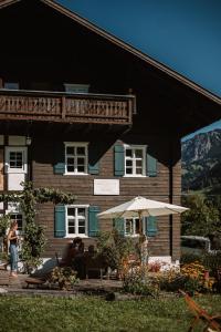 a wooden house with people sitting in front of it at Hus Sigritta in Vandans