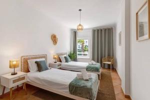 a bedroom with two beds and a window at Apartamento T3 Santa Luzia - G in Santa Luzia +21 photos