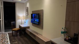 een woonkamer met een televisie aan de muur bij Carom Hotel Manali in Manāli