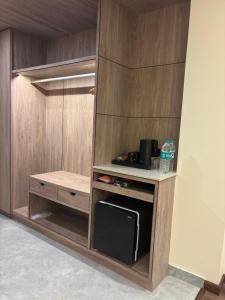 een kleine keuken met een magnetron en een fornuis bij Carom Hotel Manali in Manāli