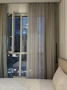 een slaapkamer met een bed en een groot raam bij ARĞYN Apartments, 3-BR Central in Astana