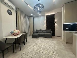 een woonkamer met een bank en een tafel bij ARĞYN Apartments, 3-BR Central in Astana +11 foto's