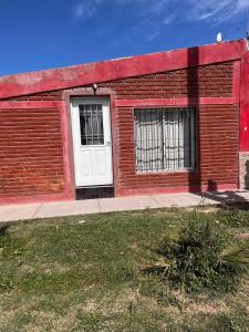 een rood bakstenen gebouw met een witte deur bij Guiñazú in Junín