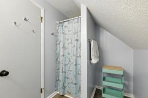 a bathroom with a shower curtain with a sailboat pattern at The Holiday House w Dock in Townville +39 photos