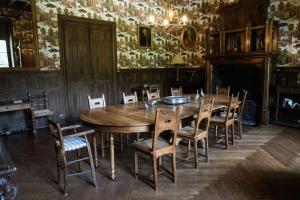 a dining room with a wooden table and chairs at Château des Faugs in Boffres