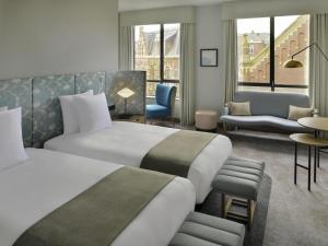 a hotel room with two beds and a couch at Mövenpick Hotel The Hague in The Hague +79 photos