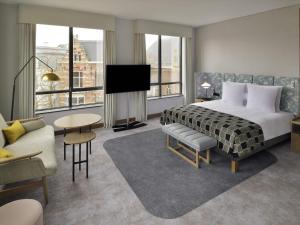 a hotel room with a bed and a tv at Mövenpick Hotel The Hague in The Hague