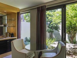 Un comedor con una mesa de cristal y sillas. en No5 Boutique Art Hotel by Mantis, en Port Elizabeth