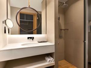 a bathroom with a sink and a mirror at Mercure Dubai Gold District in Dubai
