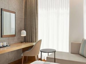 a bedroom with a desk and a chair and a mirror at Mercure Dubai Gold District in Dubai +100 photos