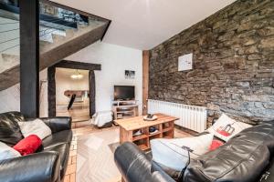 a living room with a couch and a stone wall at Les Gites Leyetaz in Châtillon-sur-Cluses