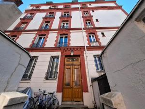 a tall building with a wooden door in front at Saint-Mandé studio, proche metro Ligne 1 & Paris Centre, Wifi rapide, Ideal couple, télétravail in Saint-Mandé