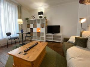 a living room with a couch and a table at Saint-Mandé studio, proche metro Ligne 1 & Paris Centre, Wifi rapide, Ideal couple, télétravail in Saint-Mandé