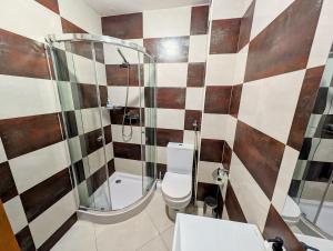 a bathroom with a toilet and a glass shower at Tabanka Azul - 2 BdR Cozy and Comfort Apt Near UN in Praia