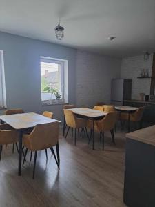 a dining room with tables and chairs and a window at Stary Młyn in Glinik