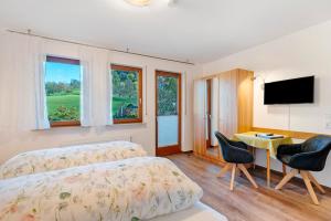 una camera da letto con un letto, una scrivania e una televisione di Pension Schneider a Freiamt