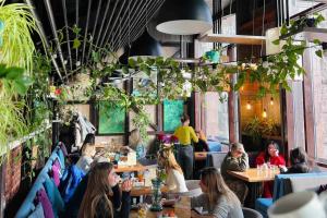 a group of people sitting at tables in a restaurant at Khreshchatyk Apart Hotel 911 in Kyiv