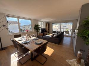 a living room with a table and a couch at Mountain View Apartment in Schattdorf