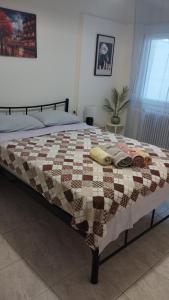 a bed with a quilt on it in a bedroom at Maraki's house in Kavala