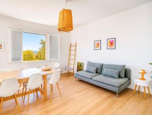 un salon avec une table et un canapé dans l'établissement Gîte Le Vélo Rouge - Airco & Parking, à Sarlat-la-Canéda