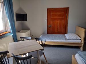 a small room with a bed and a table and chairs at Agroturystyka Pod Orzechem in Lubiąż