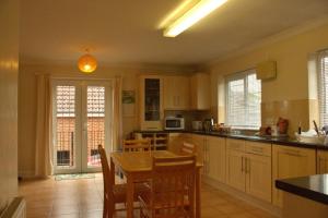 ステーンズにあるThe Penton Guest Houseのテーブルと椅子が備わった広いキッチン