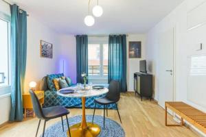 a living room with a table and a couch at Le Venise I Private Parking I Spacious & Bright in Colmar +19 photos