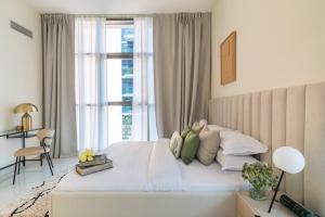 une chambre blanche avec un grand lit avec une fenêtre dans l'établissement 1bedroom Apartment At Loreto, à Dubai Marina