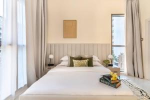 une chambre avec un grand lit blanc et une fenêtre dans l'établissement 1bedroom Apartment At Loreto, à Dubai Marina 22 autres photos