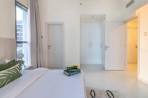 - un salon avec un lit blanc et une fenêtre dans l'établissement 1bedroom Apartment At Loreto, à Dubai Marina