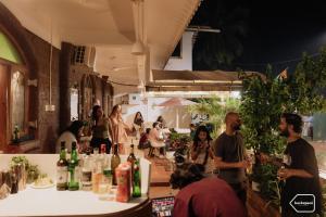 a group of people standing around a bar with wine bottles at Backspace Anjuna Beach in Anjuna
