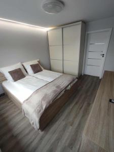 a bedroom with a large bed and a wooden floor at Ági kuckó in Nyíregyháza