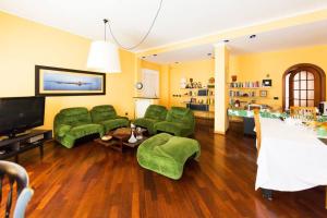 salon z zielonymi kanapami i telewizorem w obiekcie I Quattro Gattoni w mieście Napoli