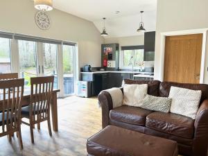 a living room and kitchen with a couch and a table at Dwrgi in Llanybyther