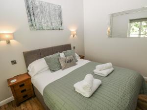 a bedroom with a bed with two towels on it at Dwrgi in Llanybyther