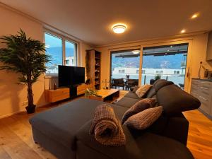 a living room with a couch and a tv at Mountain View Apartment in Schattdorf