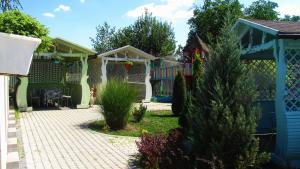 a backyard with a pergola and a house at Mini Hotel Leon in Lalovo