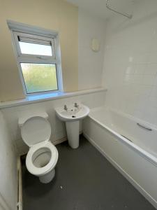 a bathroom with a toilet and a sink at Luqman Property in Swansea +8 photos