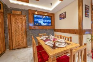 a dining room with a wooden table and chairs at Monal Homestay in Kulu