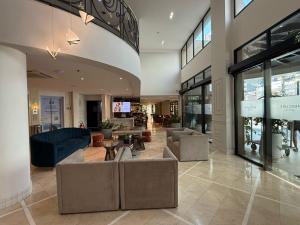 a lobby with couches and tables in a building at Flat Hotel de luxo em Moema, São Paulo in São Paulo