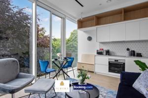 eine Küche und ein Wohnzimmer mit Tisch und Stühlen in der Unterkunft Stylish 2BDR Apartment With Cinema, Gym and Free Parking By Aurora WorkNest Short Lets & Serviced Accommodation London in Kew Bridge