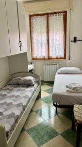 a bedroom with two beds and a window at Casa Smeraldo in Ameglia