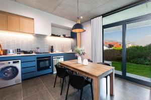 a kitchen with blue cabinets and a table with chairs at 28 Shades Myoli Beach in Sedgefield