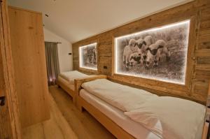 une chambre avec deux lits et un tableau au mur dans l'établissement Aletschhorn, Chalet Wiedersehen, à Grächen 8 autres photos