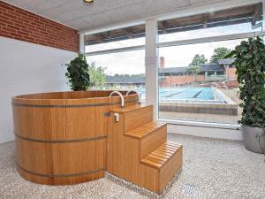 a wooden bath tub in a room with a pool at Gilleleje Holiday Centre in Gilleleje