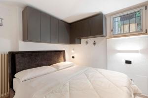 ein Schlafzimmer mit einem großen weißen Bett mit braunen Schränken in der Unterkunft Casa Lara e Gaia - Aosta Centro in Aosta