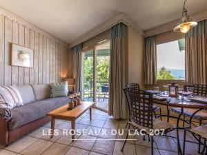 a living room with a couch and a table at Les Roseaux du Lac - 7 appartements situés dans une résidence posée au bord du lac d'Annecy in Duingt