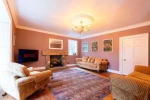 a living room with two couches and a fireplace at The Vicarage in Billingham