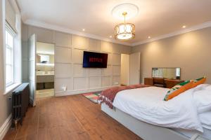 a bedroom with a bed and a tv on the wall at The Vicarage in Billingham